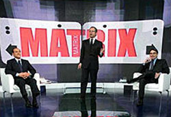 Silvio Berlusconi e Oliviero Diliberto a <i>Matrix</i>” /><br />
In una società sempre più  “digitale”, in cui la componente immateriale è arrivata a prevalere su quella sensibile, <strong>la Tv ha smesso di “distorcere” la realtà e ha iniziato a “generare” una propria realtà</strong> che lo spettatore medio introietta a forza nel proprio vissuto, arrivando a modellare su di essa le proprie percezioni. Spiegato così può sembrare il quarto episodio della saga di Matrix (quella con Neo, non quella con Mentana), ma basta ragionare un po’ sul modo in cui ci vengono presentati i fatti di cronaca nei telegiornali e nei rotocalchi televisivi per rendersi conto di quanto l’allarme che lancio sia almeno in parte giustificato.</p>
<p>Detto questo, torniamo alla campagna elettorale in corso: <strong>una fotografia ritoccata non è meno reale di una fotografia non ritoccata</strong>, perlomeno finché non ci capita di incontrare di persona il soggetto in essa riprodotto.<br />
Allo stesso modo, le opposte visioni della realtà proposte da Prodi e Berlusconi, se caricate di un pathos sufficiente nell’attimo in cui il teleschermo le riflette nei nostri occhi, diventano due realtà che chiunque può convincersi di esperire. In barba ai dati e alle cifre, oggi la virtualità è solo una realtà in attesa di certificazione. E la certificazione gliela può dare ognuno di noi.<br />
Certo, poi può succedere che nei prossimi cinque anni qualcuno si arricchisca o al contrario perda il lavoro, che l’economia cresca o che anche noi si faccia la fine degli argentini, che la disuguaglianza sociale si acuisca o meno, che le code agli sportelli si azzerino o diventino chilometriche. Ma questo la Tv non può dircelo, non è di sua competenza.</p>
<p>Adesso gira anche a voi la testa, vero?<br />
Perfetto, vuol dire che è giunto il momento di trarre le conclusioni, che si riassumono in un potente paradosso. A mio parere, non ha senso che all’elettore venga richiesto [img4]di esprimersi in modo da poter incidere sulla realtà se il bagaglio di nozioni che gli è stato fornito è esclusivamente virtuale.<br />
Il sistema è bacato, le vie d’uscita sono due.<br />
O ridimensioniamo il ruolo della Tv, oppure prendiamo atto della sua centralità e ci dotiamo di una competenza sufficiente a sostenerla e a comprenderla in modo corretto. Tenendo però conto che si voterà tra pochi giorni, questa seconda ipotesi risulta nei fatti poco praticabile per i più.<br />
<strong>Una campagna elettorale è un momento troppo delicato per poter essere affrontato in modo incosciente</strong>: per una volta, cari (e)lettori, invito voi e me a non dare troppa importanza al teleschermo.<br />
Usciamo per strada, guardiamoci intorno, la partita del 9 aprile si gioca su questo campo. </p>
				<p class=